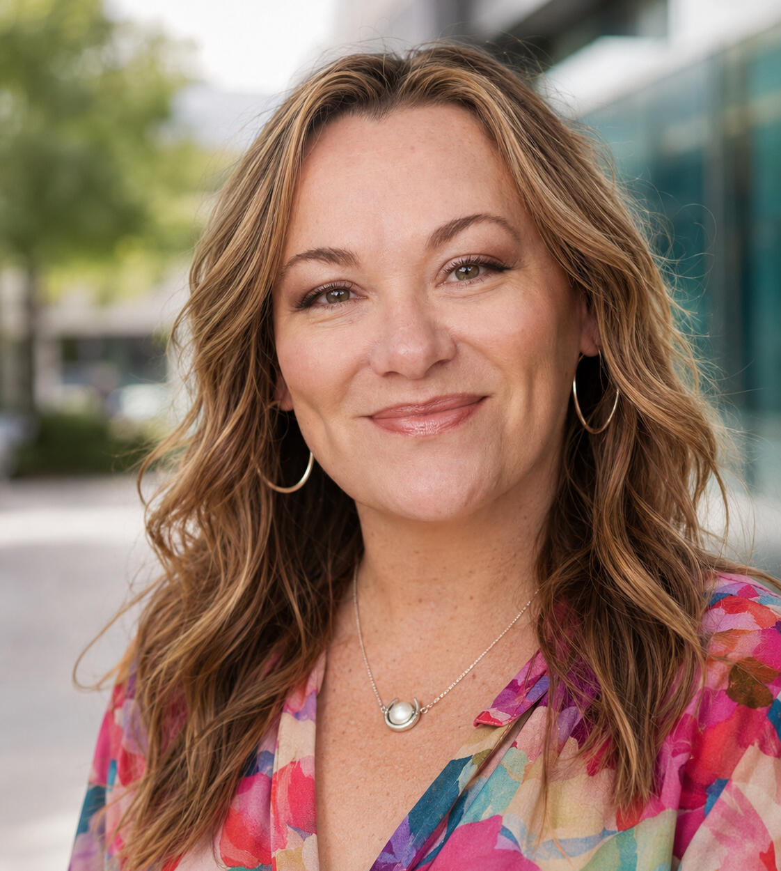 Jennifer Fish photograph of white woman with long brown hair, wearing a colorful blouse.
